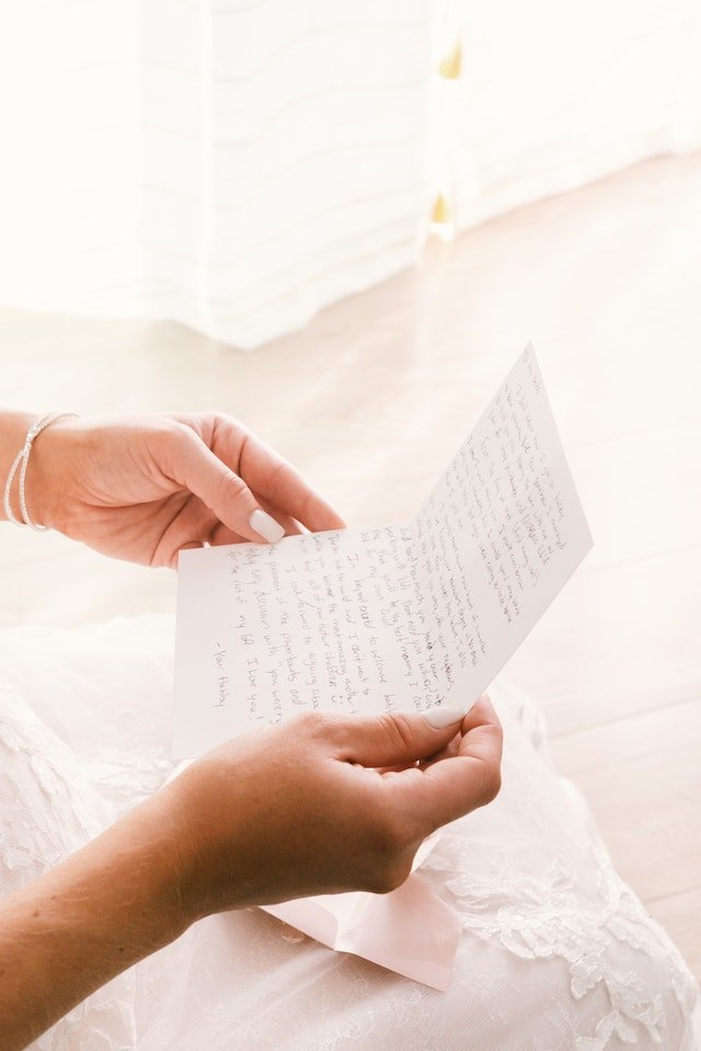 A woman reads a handwritten letter