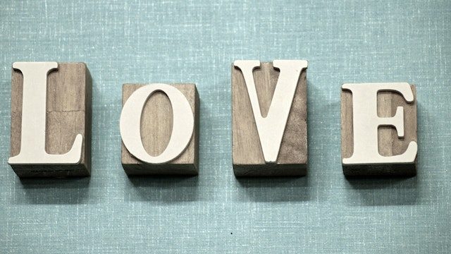 Wooden blocks with letters stuck onto them, spelling 'Love'