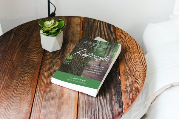 Refresh book lying on a round table next to a potted plant